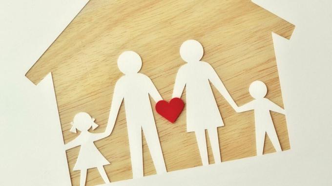 Papierová rodina na drevenom dome, ktorá drží srdce a predstavuje lásku, podporu a pomoc s ADHD