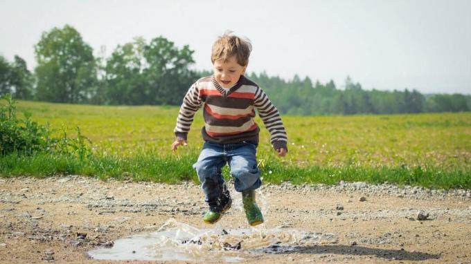 Chlapec s ADHD skákanie v blate kaluže